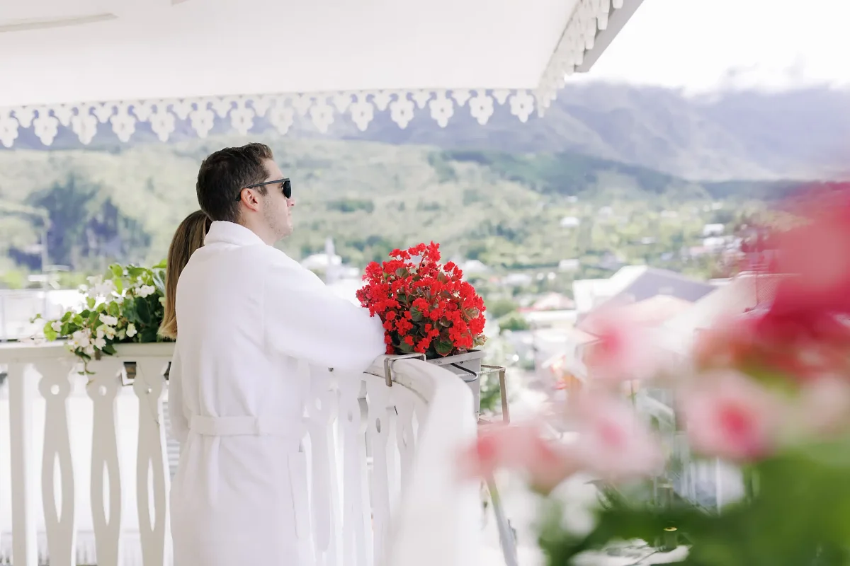 Un client en peignoir sur une terrasse fleurie du Tsilaosa, face aux montagnes