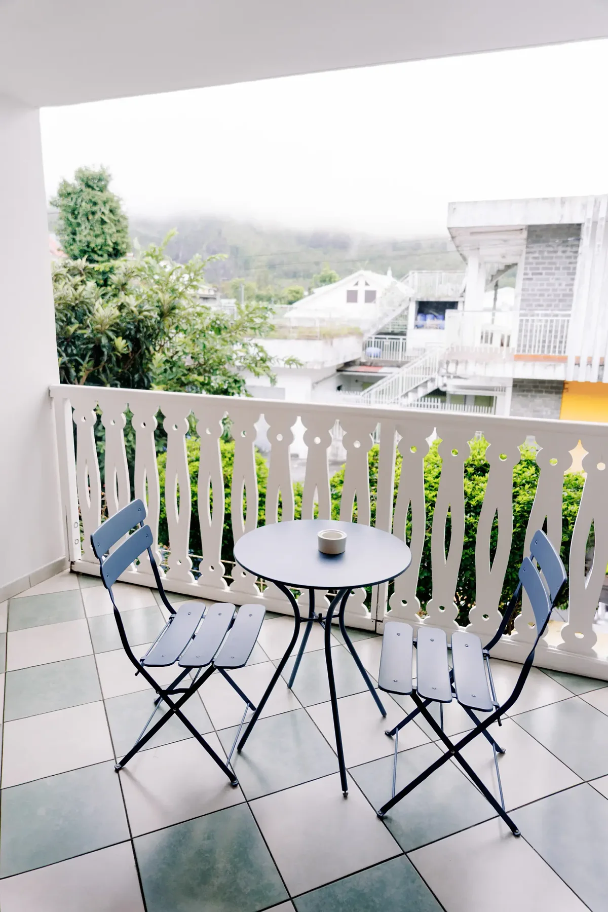 La table et les deux chaises d'une terrasse, au-dessus des toits de Cilaos