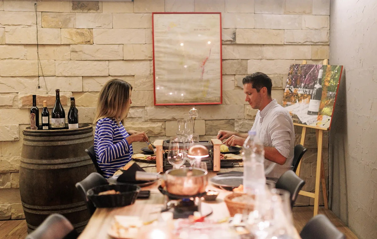 Un couple dîne entre les tonneaux du Carnotzet