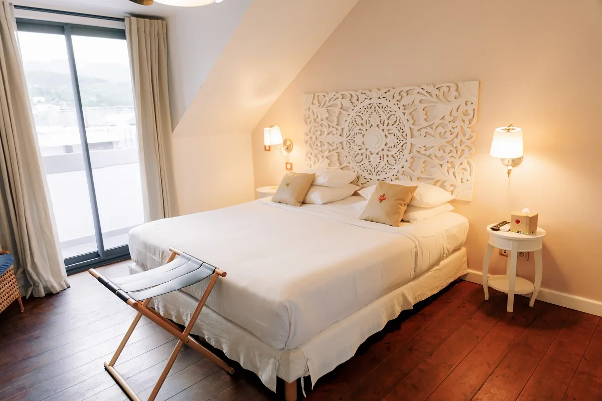 Une chambre deluxe lumineuse, son grand lit et sa baie vitrée