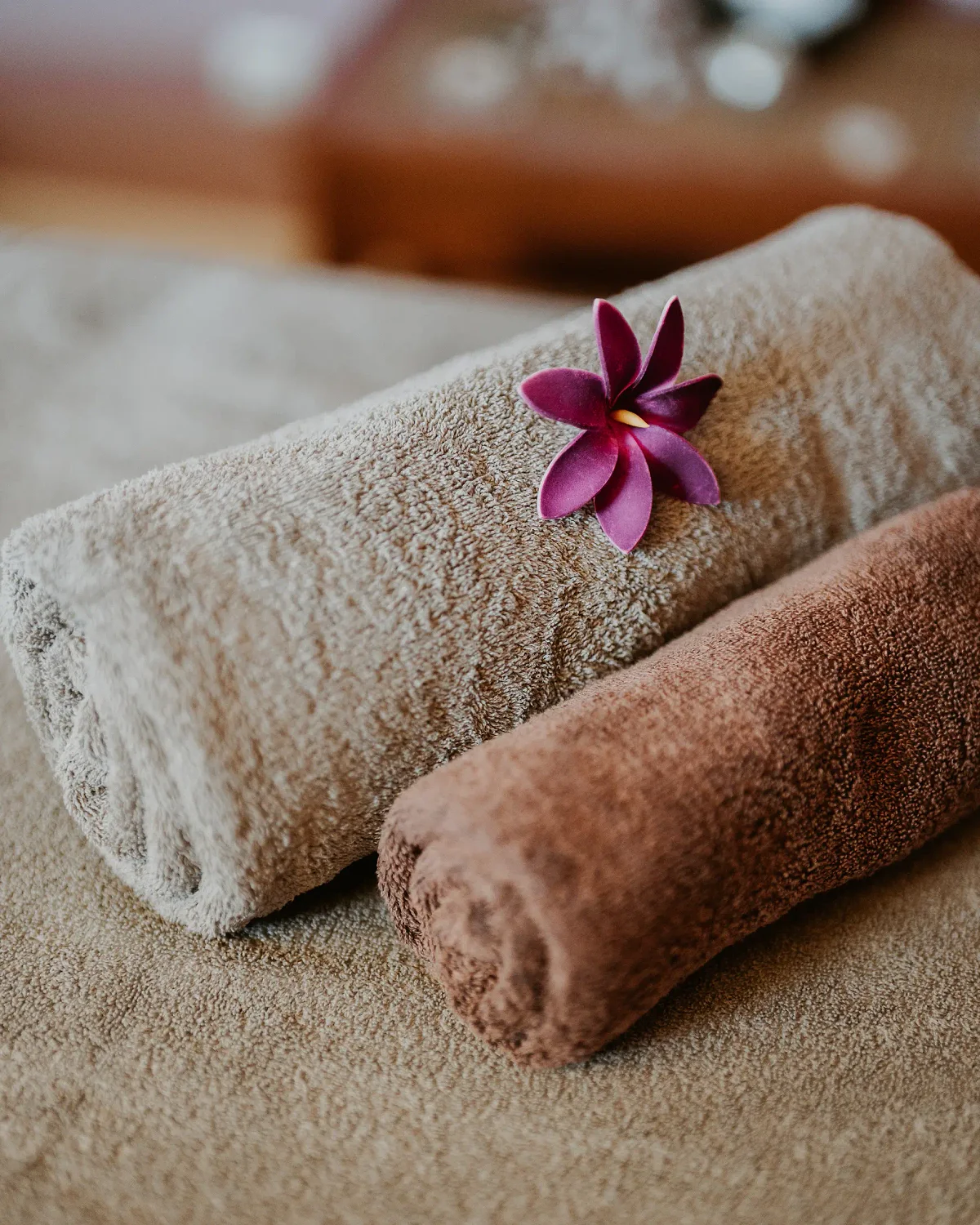 Des serviettes roulées et une fleur de frangipanier au spa du Tsilaosa